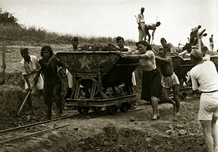 mladi guraju vagon na radnoj akciji