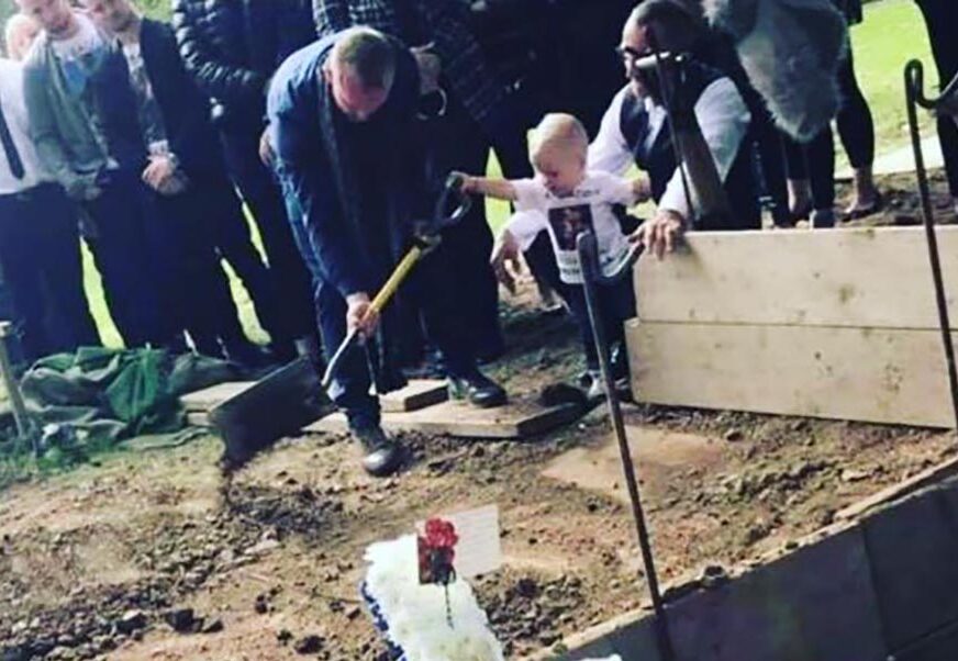 FOTOGRAFIJA KOJA SLAMA SRCA Dječak star 17 MJESECI baca zemlju u grob svog oca kojeg je ubio maloljetnik