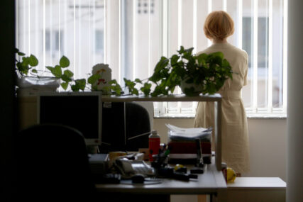 žena u kancelariji, gleda kroz prozor