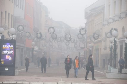 Građani šetaju, magla u gradu