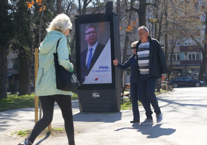 građani prolaze pored plakata na kojem je Aleksandar Vučić
