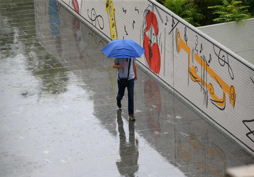 čovjek nosi kišobran