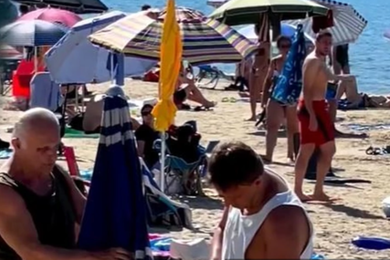 Niste vidjeli da neko ovako postavlja suncobran: Muškarac nonšalantno buši rupu u pijesku (VIDEO)