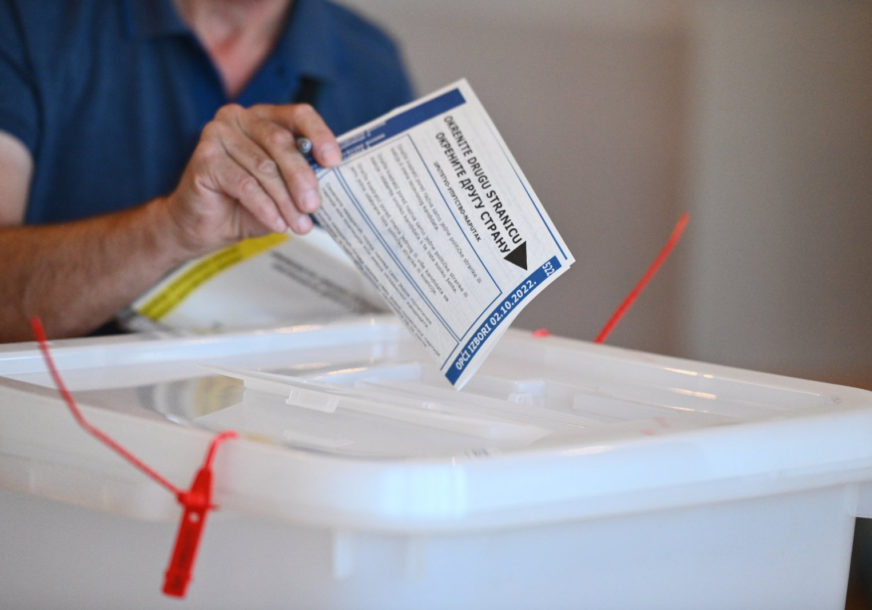 Glasač stavlja listić u glasačku kutiju