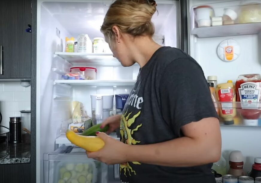 žena uzima hranu iz frižidera