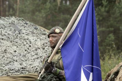 vojnik drži zastavu NATO
