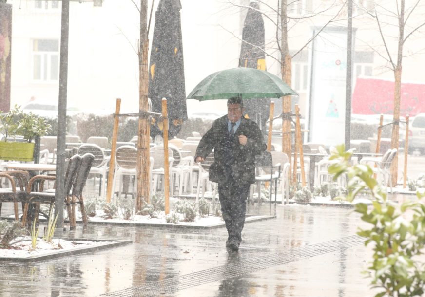 čovjek drži kišobran i hoda