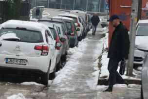 automobili i pješak na snijegu