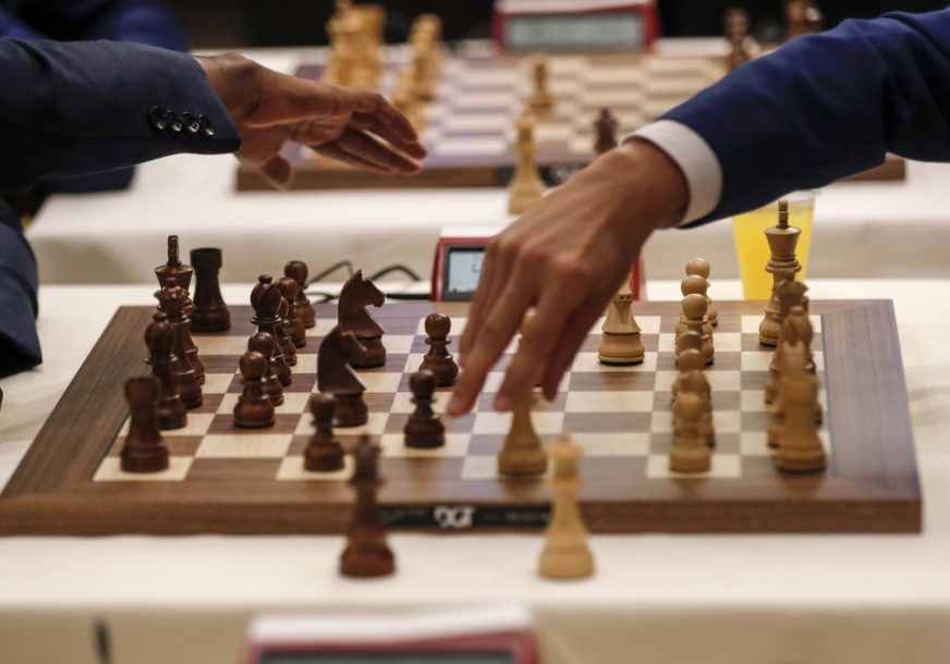 Dvije ruke nad šahovskom tablom