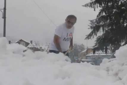 Slobodan na minusu u kratkim rukavima čisti snijeg