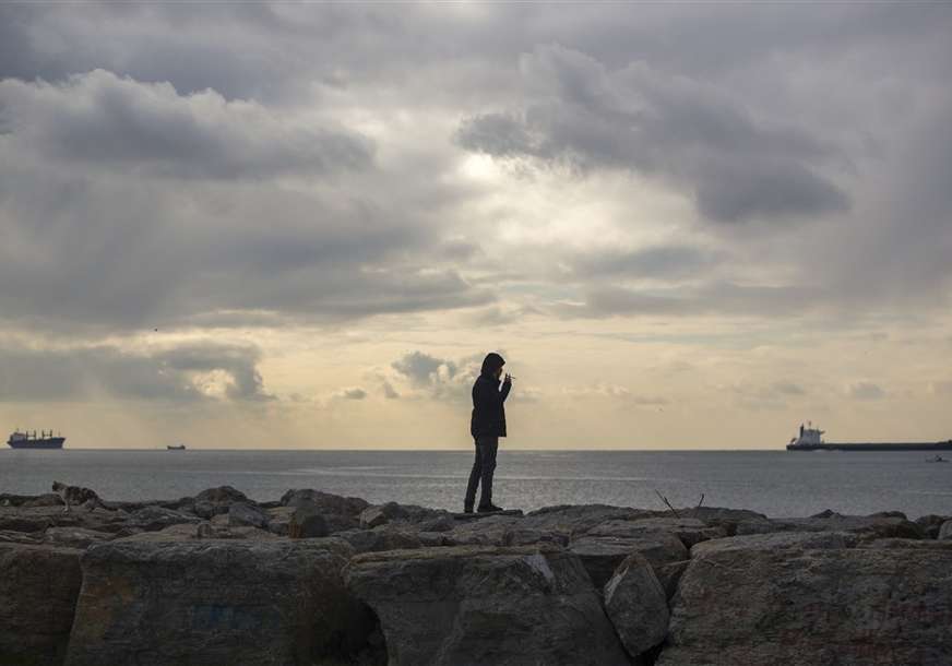 čovjek stoji na obali mora