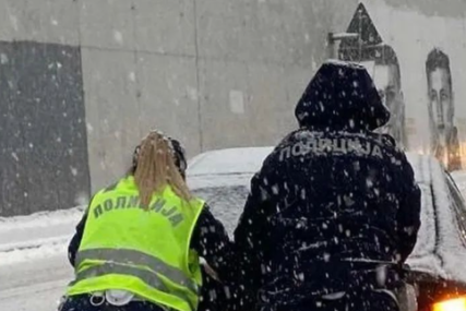 policajka pomogla vozaču koji se zaglavio u snijegu