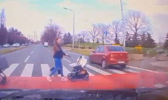Žena sa kolicima o bebom na pješačkom prelazu