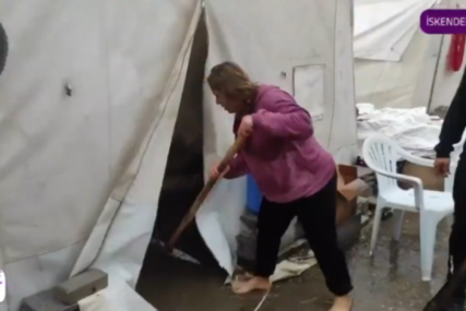 Žena izbacuje kišu iz šatora
