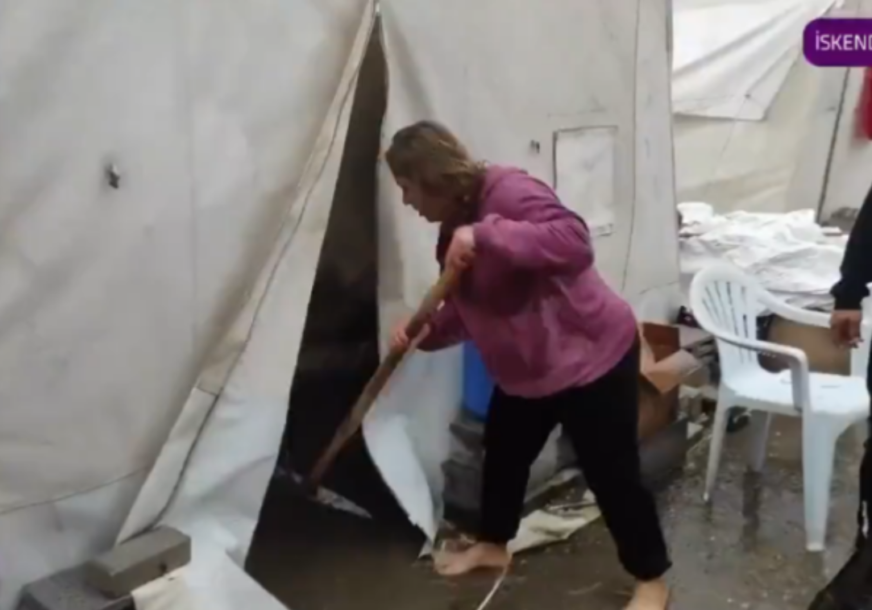 Žena izbacuje kišu iz šatora