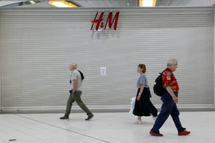Ljudi prolaze ispred zatvorene prodavnice H&M