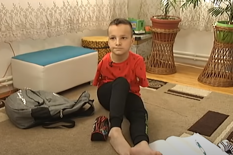 Dječak Ismail Zulfić sjedi na podu