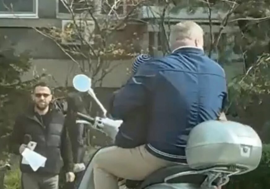 Čovjek vozi dijete na mopedu