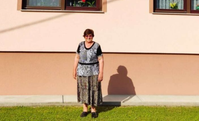 Žena stoji ispred kuće