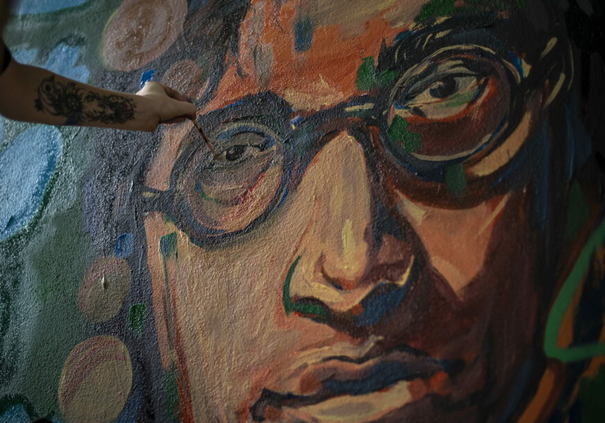 Umjetnik slika lik Džona Lenona na zidu