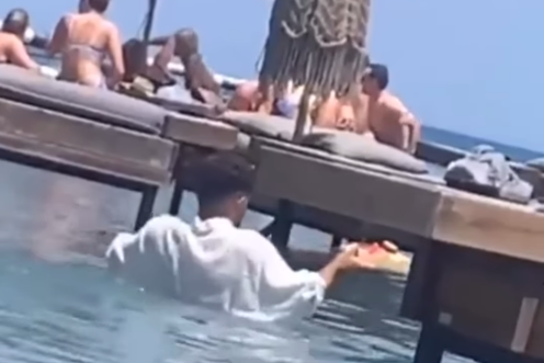 Snimak konobara kako poslužuje obučen i ide kroz vodu do gostiju