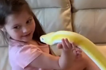 Djevojčica drži glavu zmije u ruci