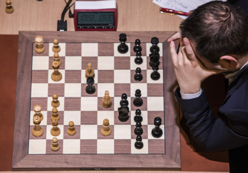 igrač razmišlja nad šahovskom tablom