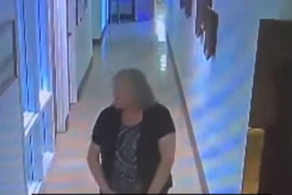 Žena hoda kroz hodnik