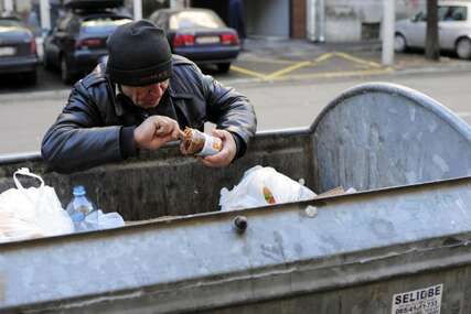 Beskućnik jede iz kontejnera