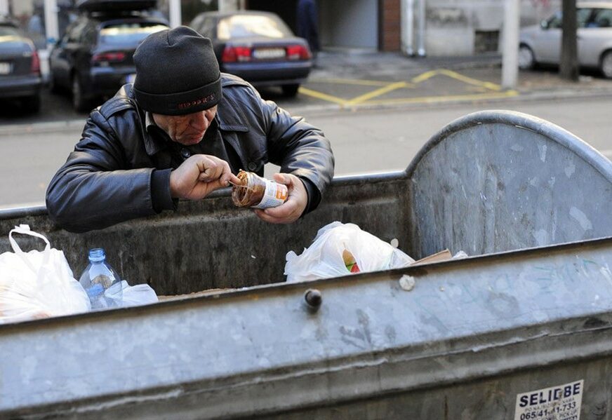 Beskućnik jede iz kontejnera