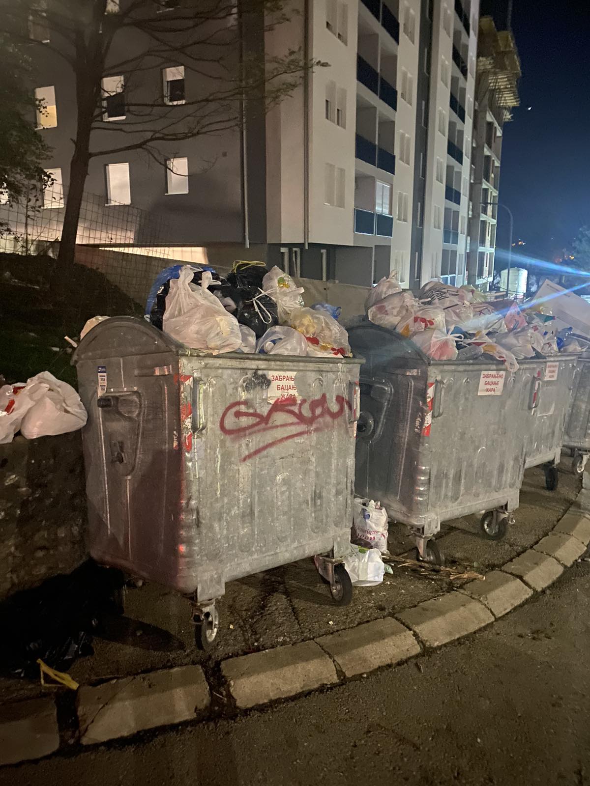 razbacano smeće na ulici i puni kontejneri
