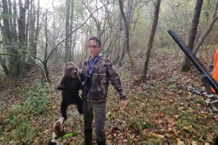 lovac drži medvejda