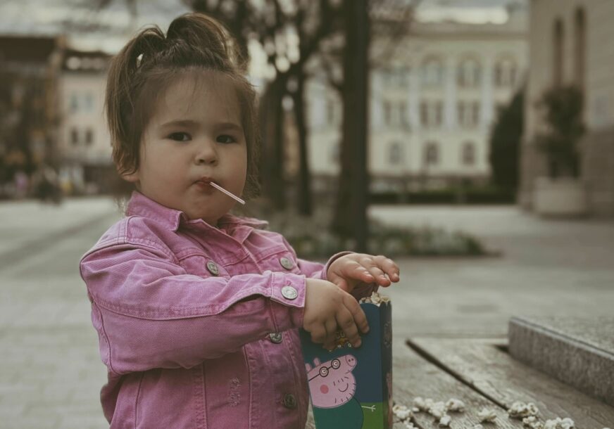 djevojčica jede kokice i šeta