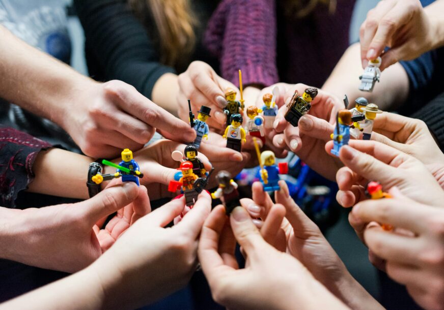 ljudi drže u rukama lego figurice