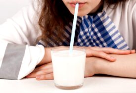 Djevojka pije mlijeko na slamku