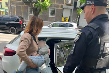 Majka sa sinom ulazi u policijski auto