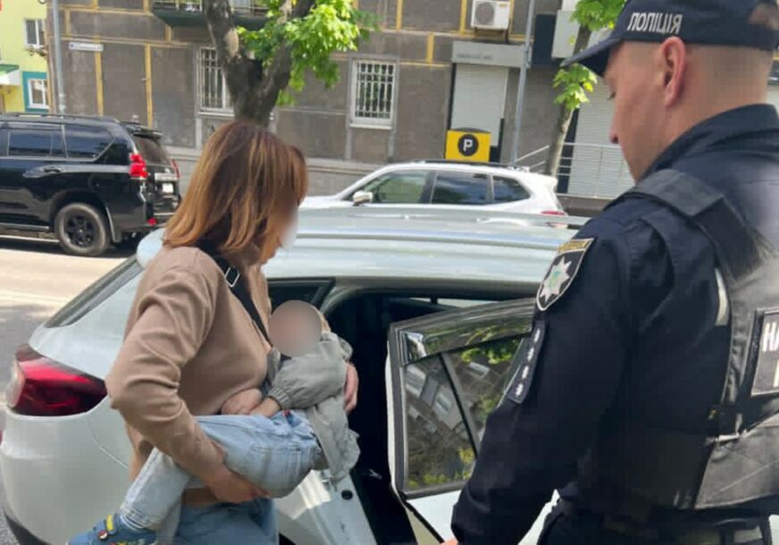 Majka sa sinom ulazi u policijski auto