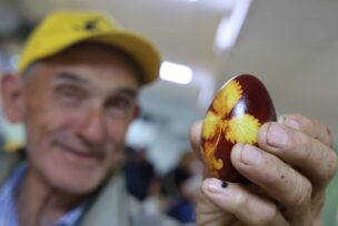 čovjek drži crveno jaje