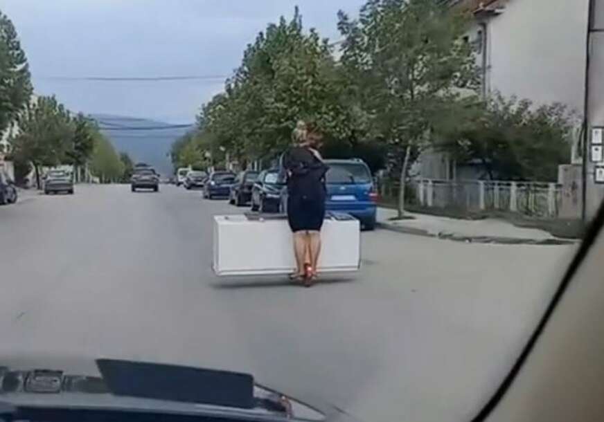 Žena prevozi frižider na trotinetu
