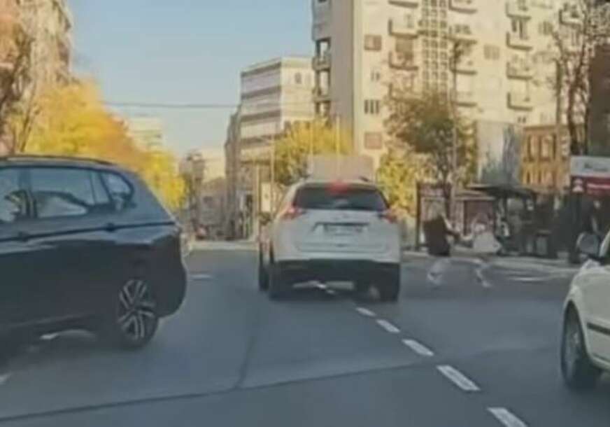 Žena pretrčava ulicu sa djetetom 