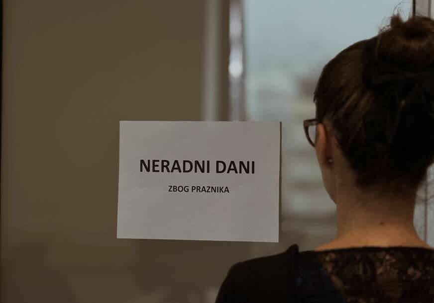 Žena gleda u natpis Neradni dani zbog praznika