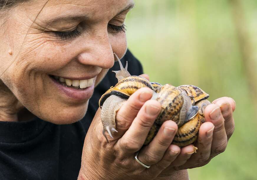 žena drži puževe u rukama