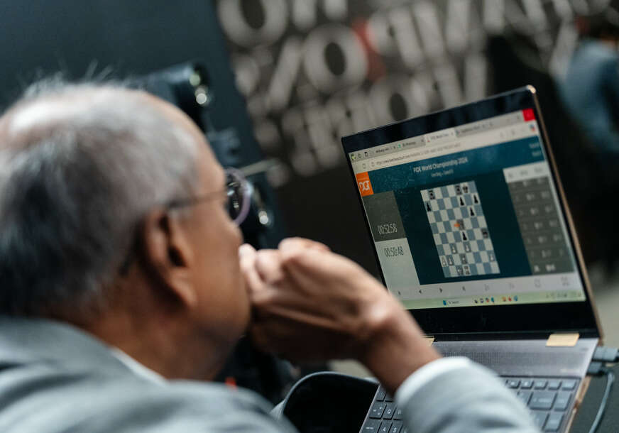 sudija na laptopu prati šestu partiju meča Ding - Gukeš