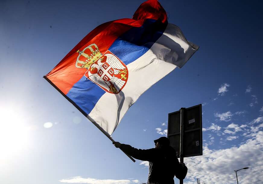 demonstrant drži zastavu Srbije