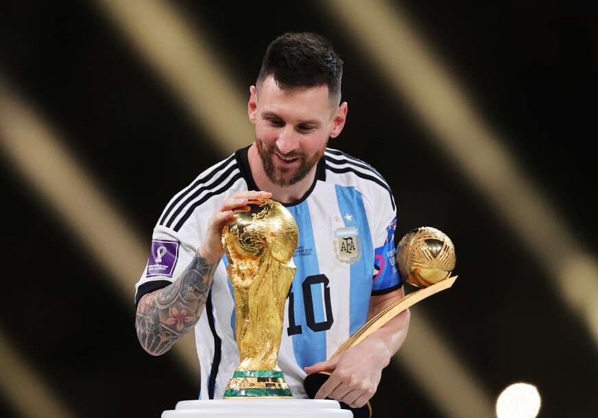 Lionel Mesi dodiruje trofej za svjetskog prvaka u fudbalu