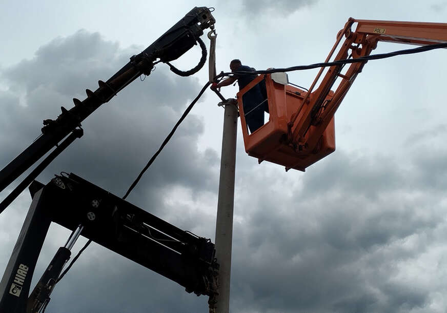 radnik postavlja kablove za struju