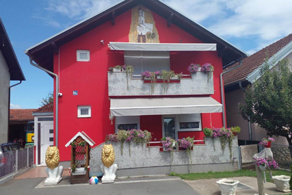 (FOTO) Crvena kao krv, čuvaju je zlatni lavovi, a NA NJOJ NASLIKAN OSTROG: Gastarbajterska kuća postala pravi HIT NA MREŽAMA