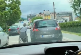 (VIDEO) POTEZ VOZAČA IZAZVAO LAVINU Čovjek u invalidskim kolicima se drži i kreće uz automobil, pljušte komentari