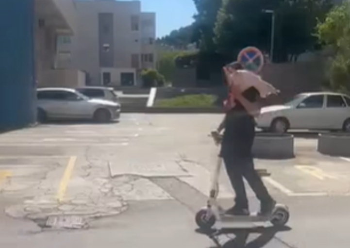 Momak sa jagnjetom na trotinetu
