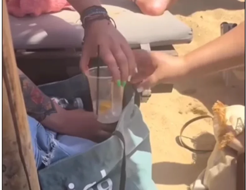 Turistkinja mućka piće na plaži